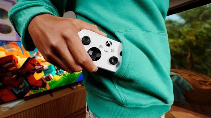 يد تحكم Xbox Nano الرسمية باللون الأبيض موضوعة في جيب السترة